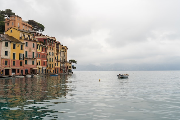 Boat on water with Colorful houses at square of Portofino.