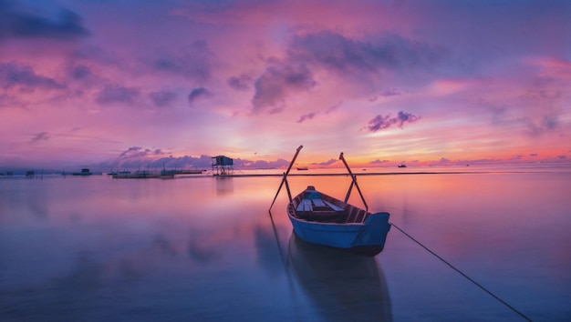 A boat on the water with a purple sky in the background