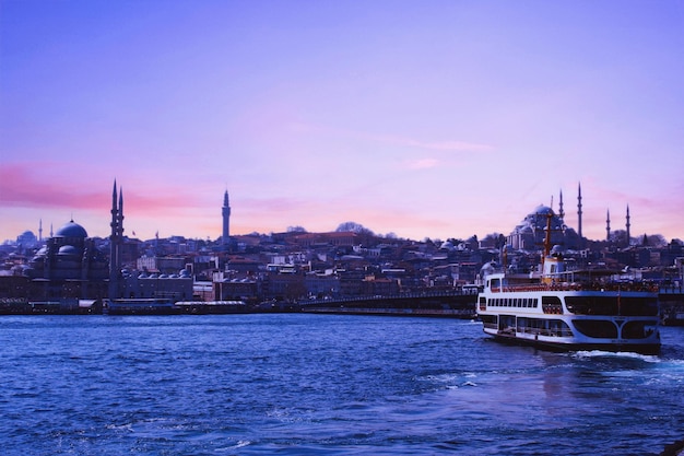 A boat in the water with a view of istanbul in the background.