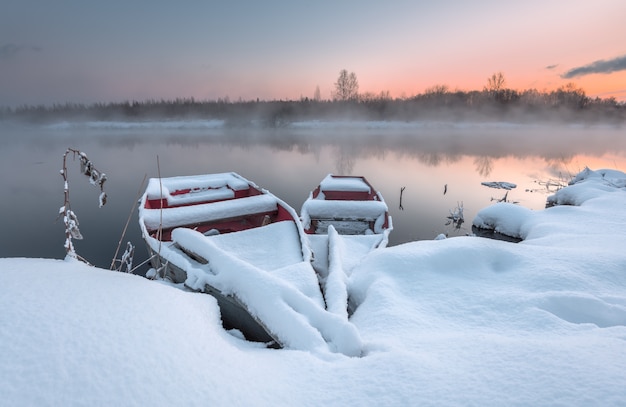 The boat in the winter on the freezing lake