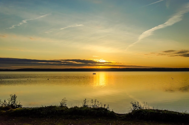 A boat with fishermen on the lake at dawn.