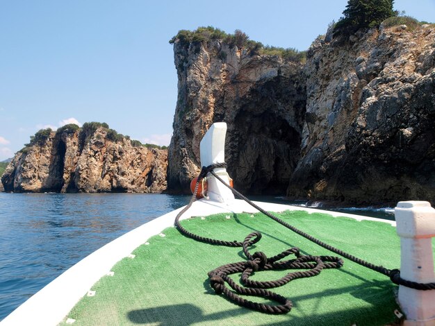 A boat with a green roof and a green stripe on the front is in the water.