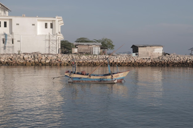 a boat with a man on the front is floating in the water