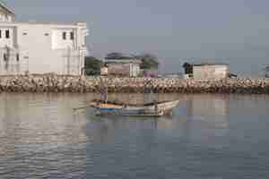 Photo a boat with a man on the front is floating in the water