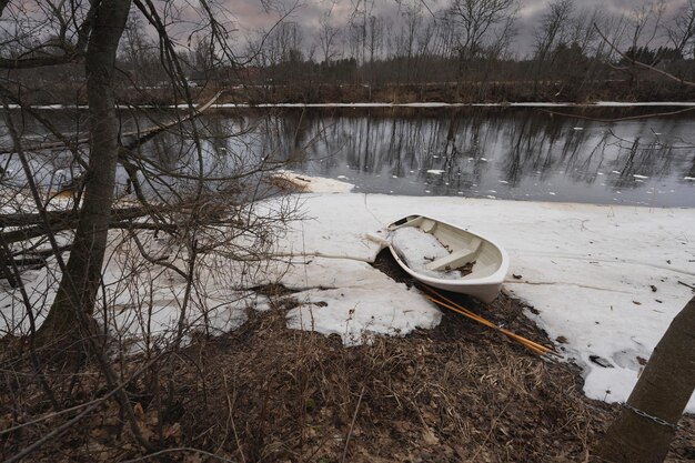 A boat with oars on the banks of the Jagala river on a winter day