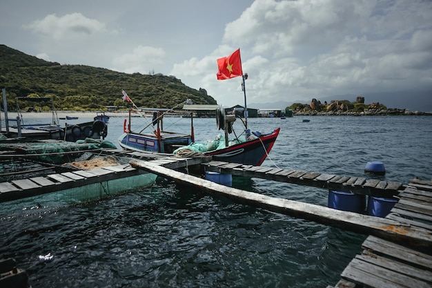 Photo a boat with a red flag on it is in the water.