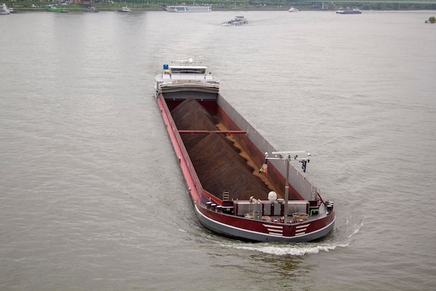 A boat with a red hull has the word " coal " on it.
