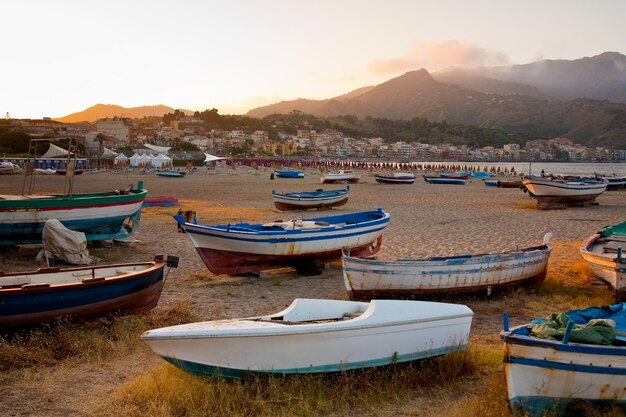 Boats on beach at sunset