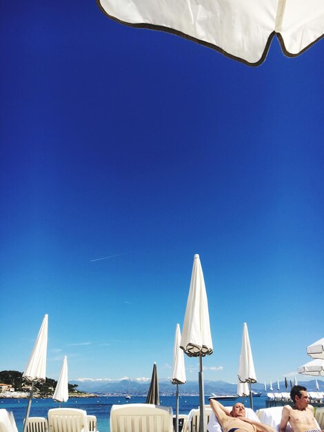 Boats in calm sea against clear sky