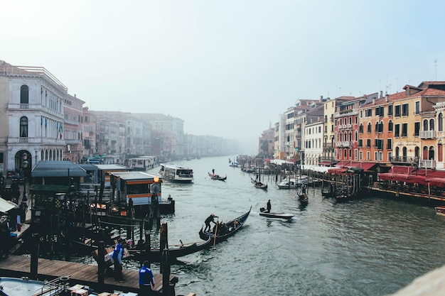 Boats in canal amidst buildings in city against clear sky