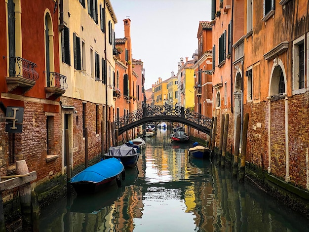 Boats docking close to a Beautiful small bridge in Venice