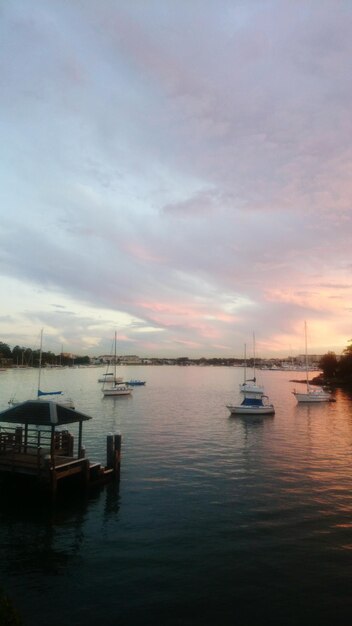 Boats in harbor at sunset