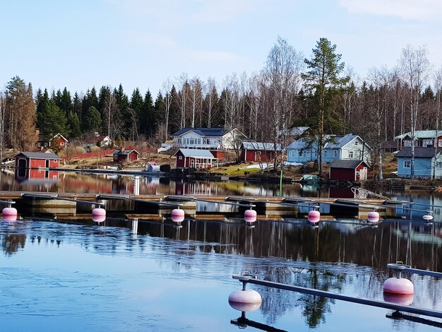 Photo boats in lake by buildings against sky