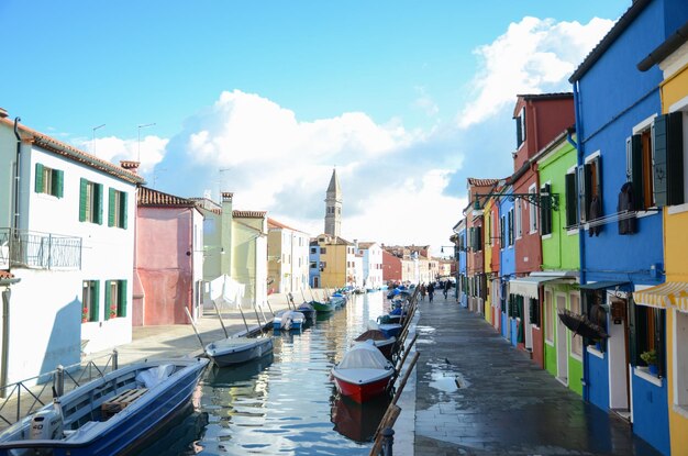 Boats moored on canal amidst buildings in city