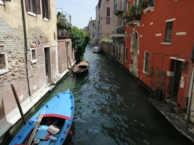 Foto barche ormeggiate nel canale in mezzo agli edifici della città