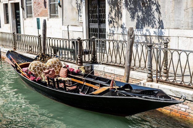 Photo boats moored in canal amidst buildings in city