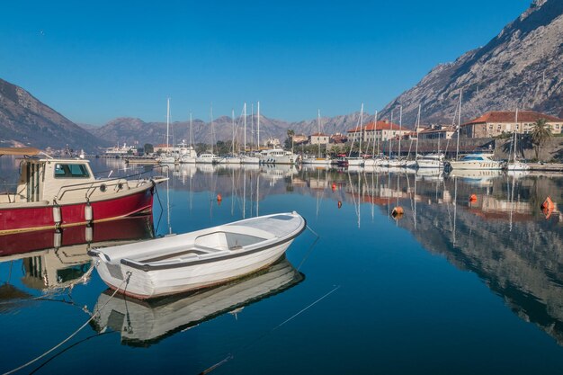 Boats moored at harbor against blue sky