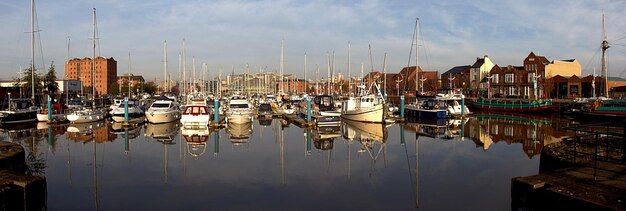 Photo boats moored in harbor against buildings in city