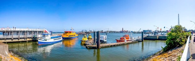 Boats moored at harbor against clear sky