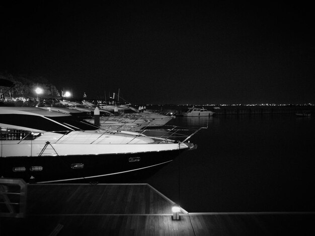 Photo boats moored at harbor against sky at night