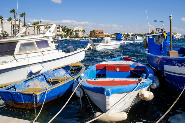 Boats moored at harbor against sky