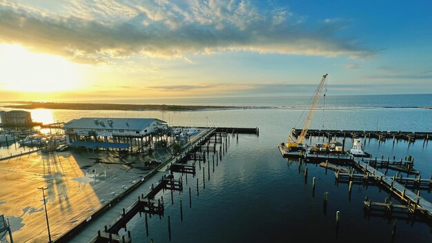 Photo boats moored at harbor during sunset