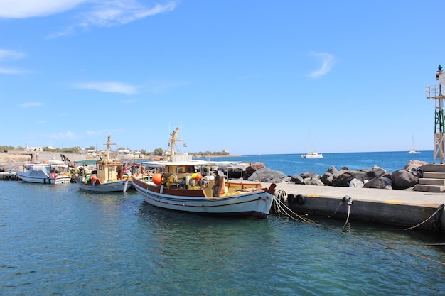 Boats moored at harbor on sea against sky