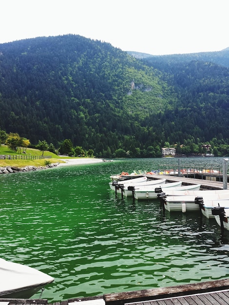 Foto barche ormeggiate nel lago contro le montagne