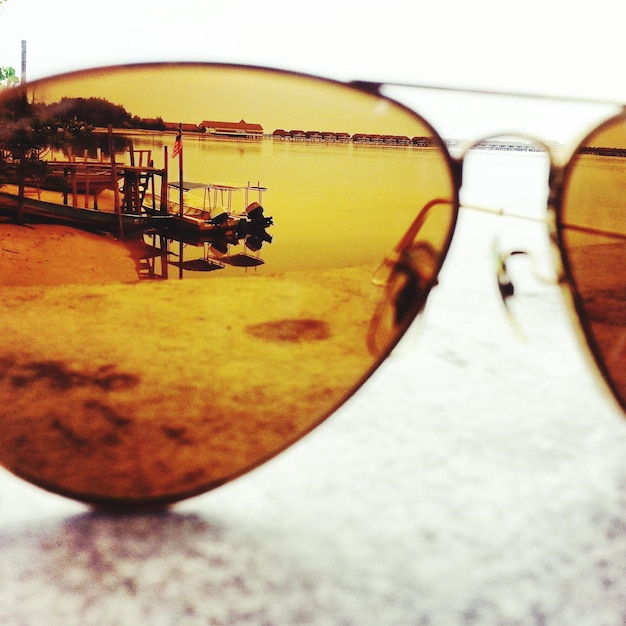 Foto barche ormeggiate sul lago viste attraverso gli occhiali da sole