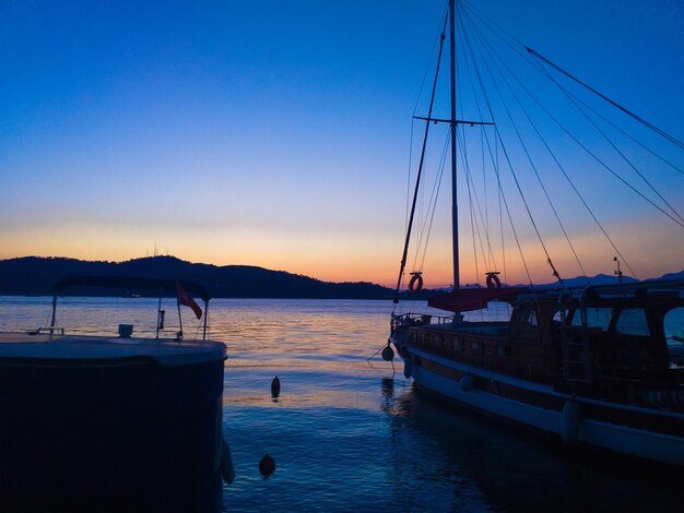 Boats moored in marina at sunset