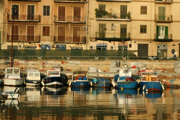 Boats moored on river against building