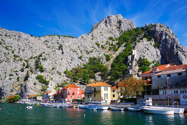 Boats moored in sea by buildings against sky