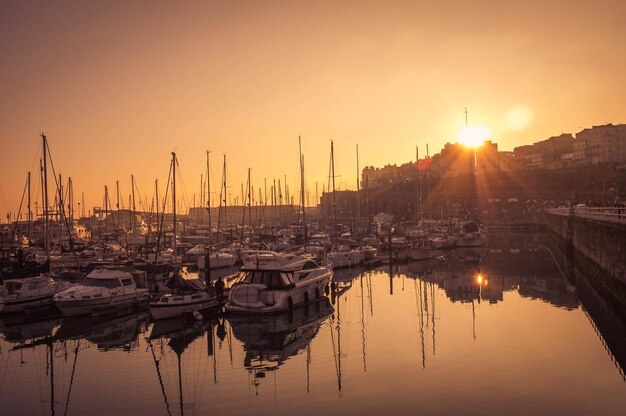 Foto barche ormeggiate in mare al tramonto