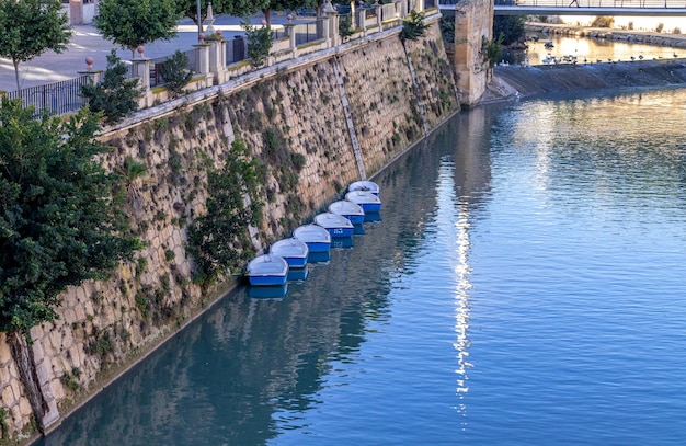 Boats parked on the bank of a river with great walls