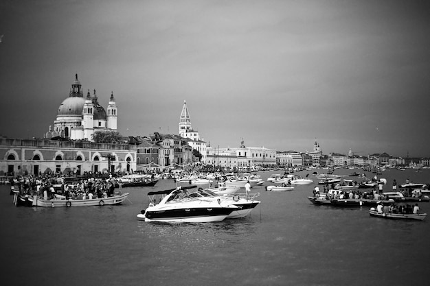 boats in river by buildings against sky in city