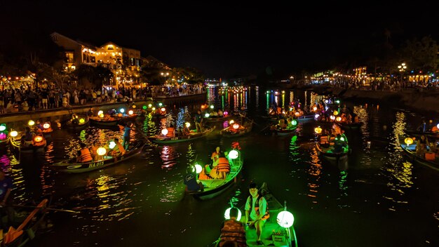 Foto barche in un fiume di notte con lanterne su di loro