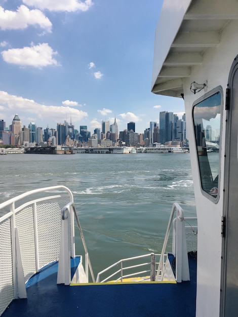 Photo boats in river with cityscape in background