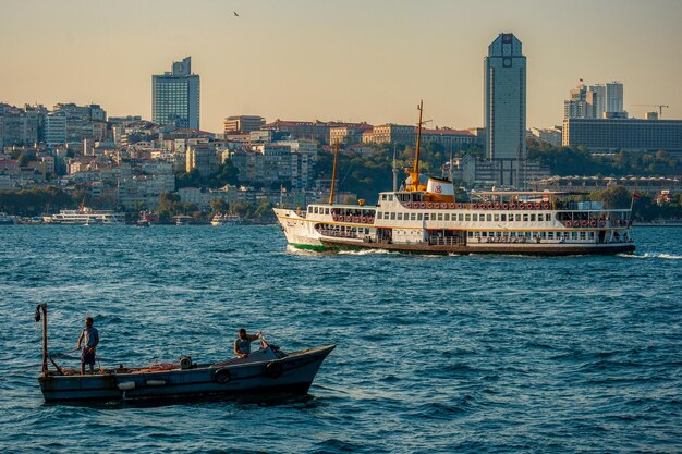 Photo boats sailing in sea against buildings