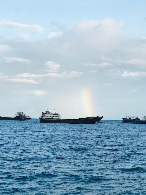 Boats sailing in sea against sky