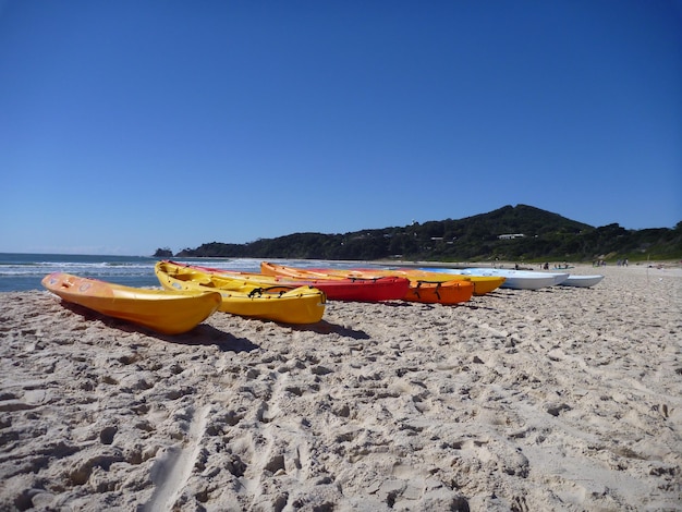 Foto barche sulla spiaggia di sabbia contro un cielo blu limpido