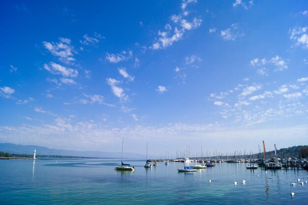 Boats in sea against blue sky on sunny day