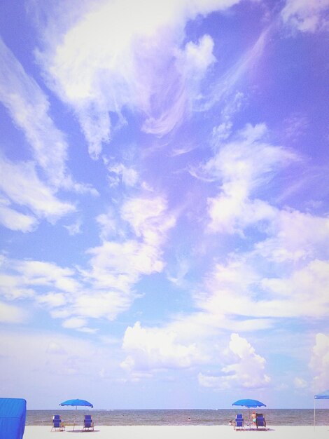 Boats in sea against cloudy sky