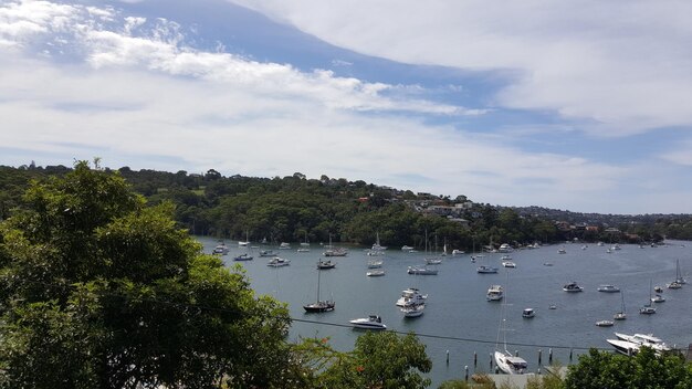 Boats in sea against cloudy sky