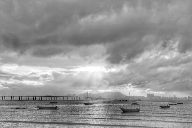 Photo boats in sea against cloudy sky