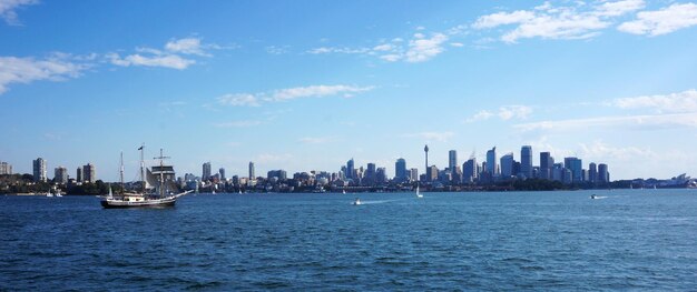 Boats in sea against skyscrapers in city