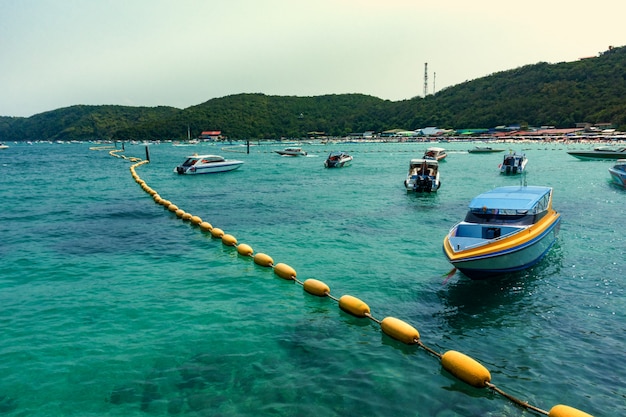 boats on sea and mountain on island