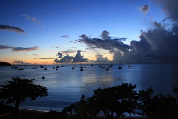 Boats in sea at sunset