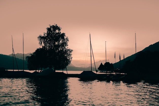 Boats in sea at sunset