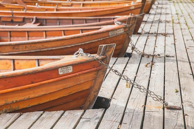 Boats with manufacturer's signs are moored by a chain on Lake Blaysko in Slovenia