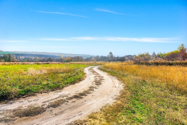 Bochtige landweg op heldere herfstdag